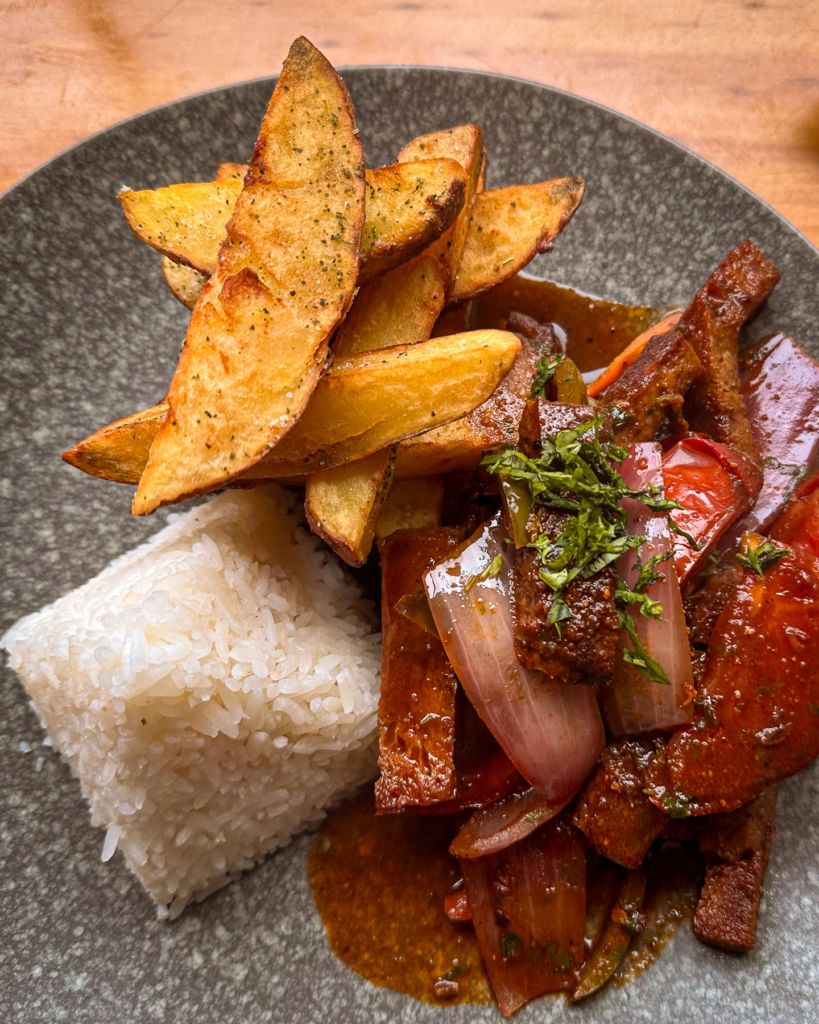 Plate of vegan lomo saltado with rice and chips in Aguas Calientes, Peru