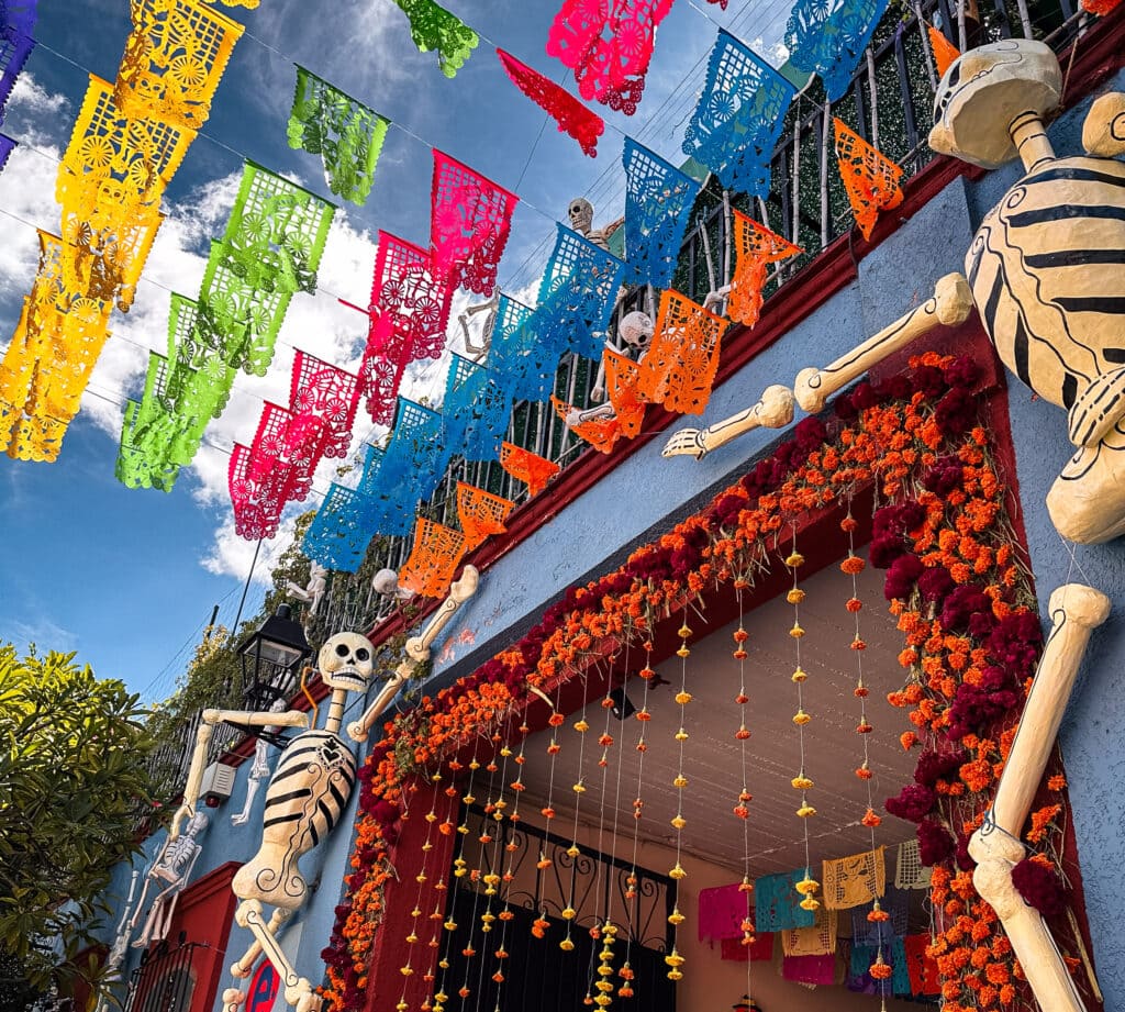 Colourful papel picado and skeleton decorations outside a building in Oaxaca during Día de los Muertos celebrations