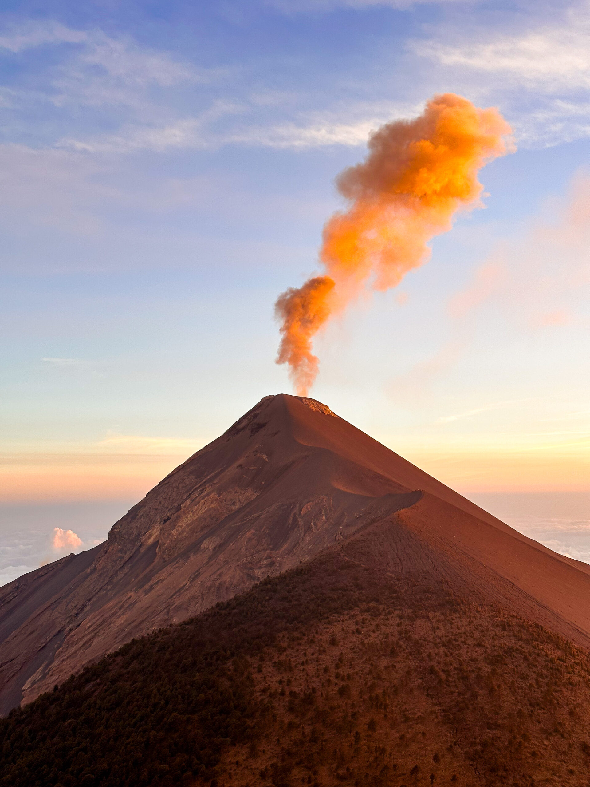 Volcán de Fuego releasing smoke at sunset as seen from Acatenango during the Acatenango hike in Guatemala